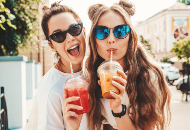 Two women drinking juice and smiling