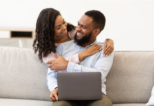 A man and woman hugging on the couch